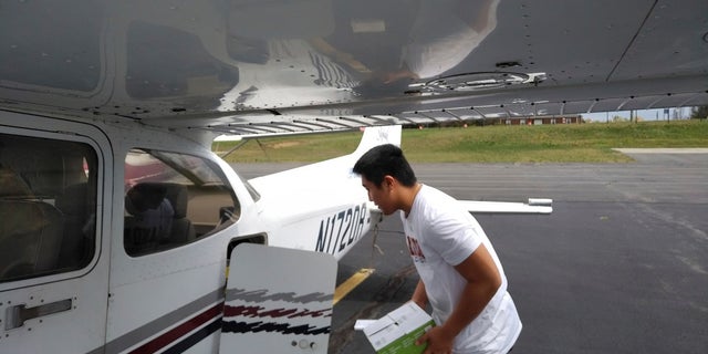 In this photo provided by Thomas Kim, TJ Kim, 16, loads medical supplies into a plane in Leesburg, Va., before flying to a hospital in Luray. Kim began delivering donated medical supplies to rural hospitals in need after realizing his flight training could be put to good use during the coronavirus pandemic. (Thomas Kim via AP)