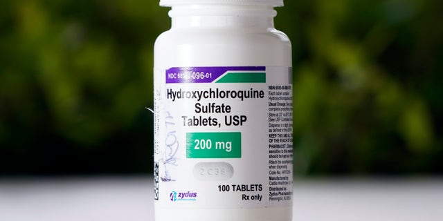 A bottle of hydroxychloroquine is displayed on a table outside The Resort at Texas City nursing home Tuesday, April 7, 2020, in Texas City, Texas. Dr. Robin Armstrong, the home's medical director, is treating nearly 30 residents of the nursing home with the anti-malaria drug hydroxychloroquine, which is unproven against COVID-19 even as President Donald Trump heavily promotes it as a possible treatment. Armstrong said Trump's championing of the drug is giving doctors more access to try it on coronavirus patients. More than 80 residents and workers have tested positive for the coronavirus at the facility. (AP Photo/David J. Phillip)