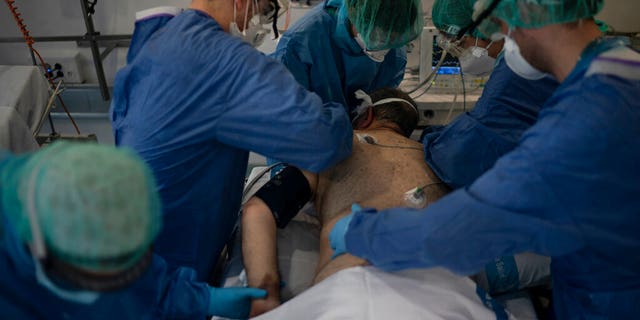 Healthcare workers assist a COVID-19 patient at a library that was turned into an intensive care unit (ICU) at Germans Trias i Pujol hospital in Badalona, Barcelona province, Spain.