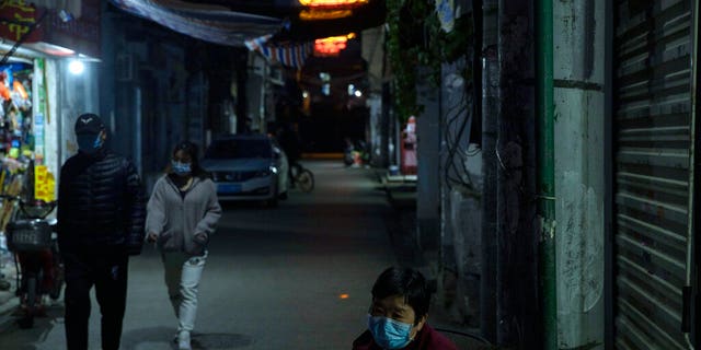 Residents wear masks against the coronavirus in an old neighborhood in Wuhan, in central China's Hubei province on Sunday, April 12, 2020.