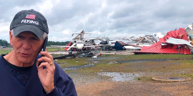 Rep. Ralph Abraham seen talking on his phone in front of a destroyed hangar and damaged planes at Monroe Regional Airport in Monroe, La.