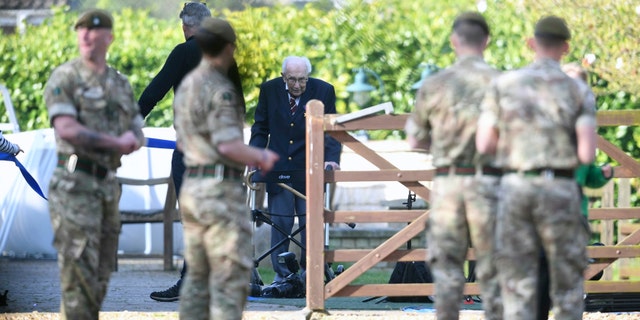 Captain Tom Moore, a 99-year-old veteran, completing the 100th length of his garden at his home in Marston Moretaine, Bedfordshire. Captain Moore has raised over 12 million pounds for the NHS after receiving donations to his fundraising challenge from around the world. Joe Giddens/PA Wire via AP