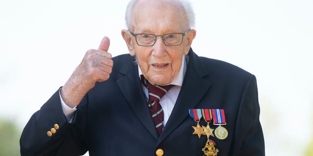 100-year-old war veteran Captain Tom Moore, poses for a photo at his home in Marston Moretaine, England, after he achieved his goal of 100 laps of his garden, raising millions of pounds for the NHS with donations to his fundraising challenge from around the world. (Joe Giddens/PA via AP)