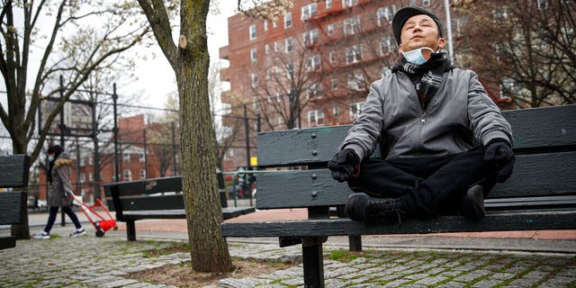 Lobsang Tseten meditates and practices breathing exercises alone to maintain social distancing at a playground in New York.