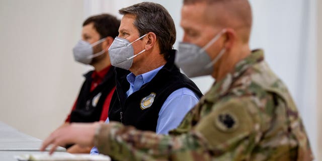 Georgia Gov. Brian Kemp listens to a speaker during a tour of a massive temporary hospital at the Georgia World Congress Center on Thursday, April 16, 2020, in Atlanta. Kemp took part in a tour of the 200-bed facility, constructed quickly in the lower levels of the Georgia World Congress Center which normally plays host to large conventions and sporting events. (AP Photo/Ron Harris, Pool)