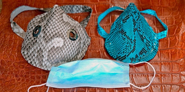 Masks made from an invasive Florida python snake are seen in Brian Wood's workshop in Dania, Fla on April 8. Wood, the owner of All American Gator Products in Dania Beach, is crafting decorative mask coverings from the skin of the Burmese python, the infamous invasive species wreaking havoc on the native wildlife of the Everglades. (Charles Trainor, Jr./Miami Herald via AP)