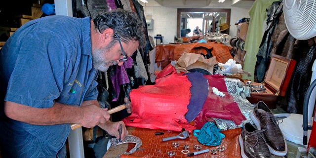 Brian Wood works on a mask made from an invasive Florida python snake in his workshop in Dania, Fla on April 8. (Charles Trainor, Jr./Miami Herald via AP)