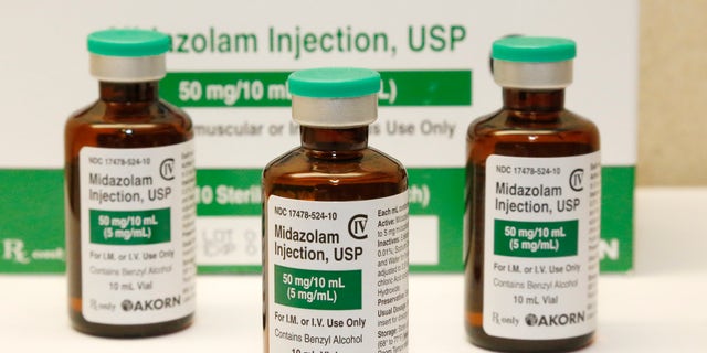 This July 25, 2014 file photo shows bottles of the sedative midazolam at a hospital pharmacy in Oklahoma City. Many of the medications being used to sedate and paralyze COVID-19 patients placed on ventilators and to also treat their pain are the same drugs that put inmates to death by lethal injection. Last month, nationwide demand for these drugs surged 73 percent during the pandemic.