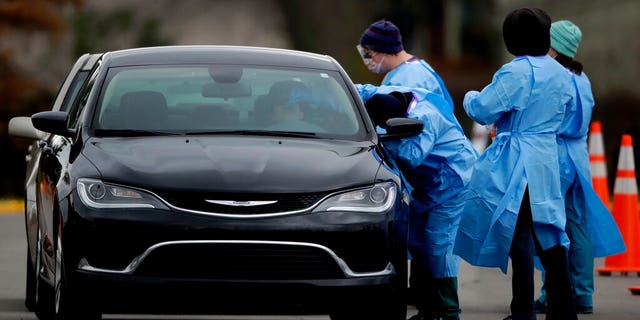 Healthcare workers from Johnson County Health & Environment test a woman for COVID-19 at a drive-in testing center Friday, April 17, 2020, in Shawnee, Kan. Kansas Democratic Gov. Laura Kelly, whose state has one of the lowest per capita testing rates in the country, told CNN it has been difficult to get testing supplies.