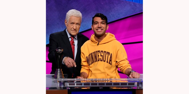 'Jeopardy!' host Alex Trebek (L) with a contestant 