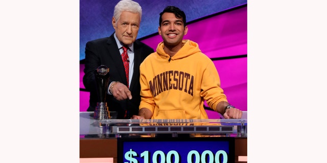 'Jeopardy!' host Alex Trebek (L) with a contestant 