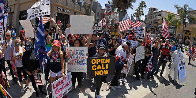 Protesters demonstrate against stay-at-home orders that were put in place due to the COVID-19 outbreak, Friday, April 17, 2020, in Huntington Beach, Calif. (Associated Press)