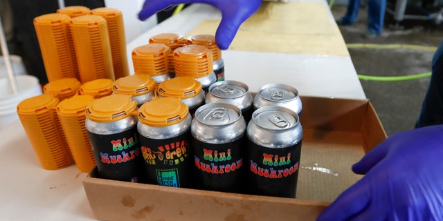 A worker puts four-pack covers on canned beers after they came off the filling conveyor at the ShuBrew craft brewery in Harmony, Pa on April 16. After the state liquor control board closed the Pennsylvania state-owned stores that retail nearly all of the state's liquor in March, the small microbrewery business pulled an all-nighter to retool its website and operations and went to online ordering and curbside pickup for patrons at their Zelienople, Pa. restaurant. (AP Photo/Keith Srakocic)