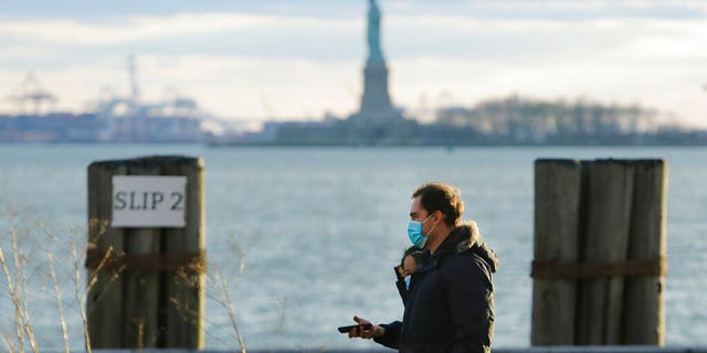 Pedestrians wearing face masks while walking in Battery Park on Saturday in New York City. (AP Photo/Frank Franklin II)