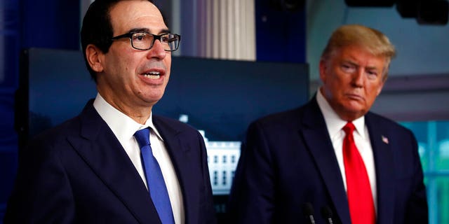 FILE - In this April 13, 2020, file photo President Donald Trump listens as Treasury Secretary Steven Mnuchin speaks about the coronavirus in the James Brady Press Briefing Room at the White House in Washington. The Trump administration and Congress are nearing an agreement as early as Sunday, April 19, on a $400-plus billion aid package to boost a small-business loan program that has run out of money and add funds for hospitals and COVID-19 testing. (AP Photo/Alex Brandon, File)