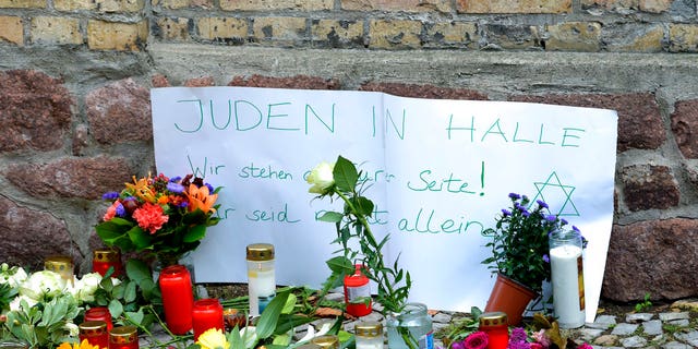 FILE: Candles and flowers are placed in front of a synagogue in Halle, Germany.