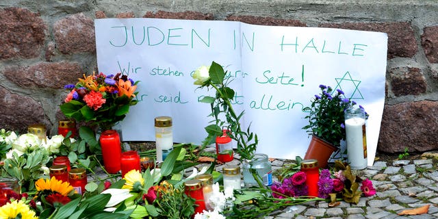 FILE: Candles and flowers are placed in front of a synagogue in Halle, Germany.