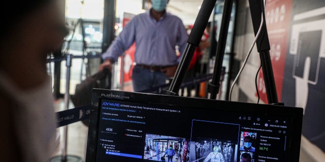 A flight passenger is screened with a thermal imaging camera at the Arturo Merino Benitez International Airport in Santiago, Chile, on April 20. (AP Photo/Esteban Felix)
