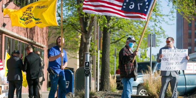 Kenton Gartrell, Patrick Ray and Garth McKinney, from left, attend a rally to protest the Yakima City Council's decision to formally censure Councilman Jason White, Tuesday, April 21, 2020, outside City Hall in Yakima, Wash.