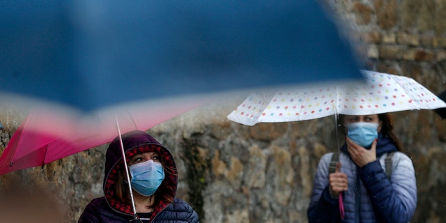 People line up during a free distribution of protective masks against COVID-19 by volunteers of the Chinese Evangelical Christian Church, in Rome, Wednesday, April 22, 2020. (Cecilia Fabiano/LaPresse via AP)