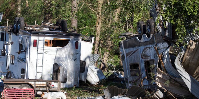 A dog walks past overturned trailers, Thursday, April 23, 2020, in Onalaska, Texas, after a tornado destroyed came through the area night before.