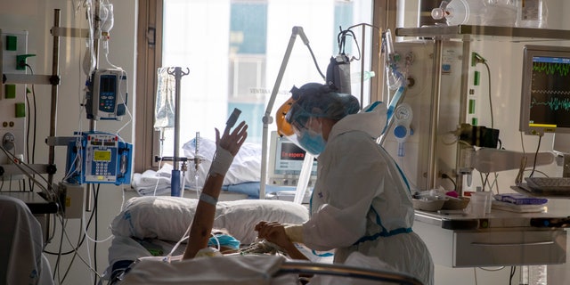 Healthcare workers assist a COVID-19 patient at one of the intensive care units (ICU) of the Ramon y Cajal hospital in Madrid, Spain on April 24. People with chronic medical conditions often have a compromised immune system, which means they are less capable of fighting off attacks from bacteria or viruses.<br data-cke-eol="1">
(AP Photo/Manu Fernandez)