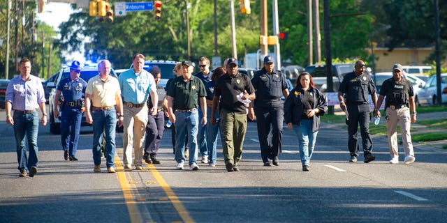 Baton Rouge Police Chief Murphy Paul, center, holding a sheet of paper, walking along a street in Baton Rouge, La., on Sunday. (Travis Spradling/The Advocate via AP)