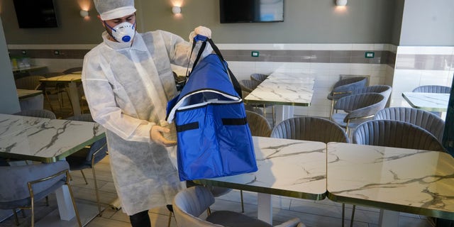 Though De Luca has lifted the bans on home deliveries for pizzerias, customers must abide by some restrictions. All orders must be placed by phone, and all businesses must close at 10 p.m. Pizzalios must wear gloves and masks at work, and the pizza shops have to be cleaned frequently.. (AP Photo/Andrew Medichini)