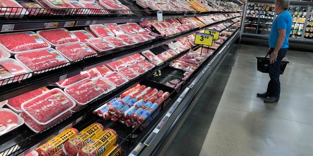 A shopper surveys the overflowing selection of packaged meat in a grocery early Monday, April 27, 2020, in southeast Denver. With closures in meat processing plants across the country because of the spread of the new coronavirus among workers, food analysts are forecasting shortages of beef, pork and poultry on the shelves of the country's supermarkets in the days ahead. (AP Photo/David Zalubowski)