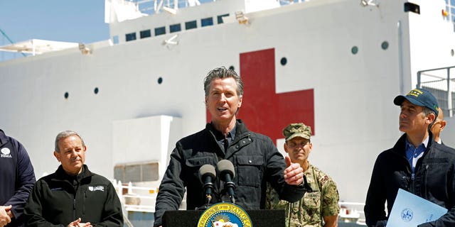 FILE: California Governor Gavin Newsom, center, speaks next to Los Angeles Mayor Eric Garcetti, right, in front of the hospital ship USNS Mercy that arrived into the Port of Los Angeles.