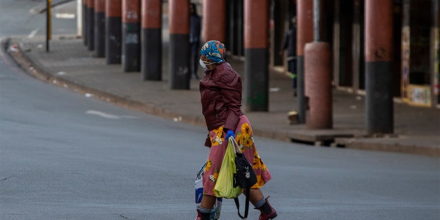 A woman wearing face masks to protect against coronavirus, walks on the street in downtown Johannesburg, South Africa, Thursday. (AP Photo/Themba Hadebe)