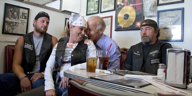 FILE - In this Sept. 9, 2012 file photo, then-Vice President Joe Biden talks to customers, including a woman who pulled up her chair in front of the bench Biden was sitting on, during a stop at Cruisers Diner in Seaman, Ohio. (AP Photo/Carolyn Kaster, File)