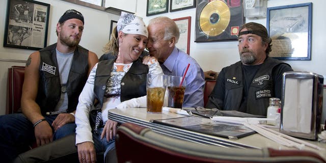 FILE - In this Sept. 9, 2012 file photo, then-Vice President Joe Biden talks to customers, including a woman who pulled up her chair in front of the bench Biden was sitting on, during a stop at Cruisers Diner in Seaman, Ohio. (AP Photo/Carolyn Kaster, File)