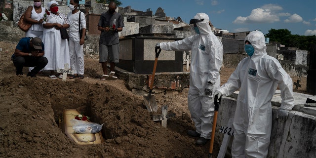 Taina dos Santos, third from left, attends the burial of her mother Ana Maria, a 56-year-old nursing assistant?who died from the new coronavirus, in Rio de Janeiro, Brazil, Tuesday, April 28, 2020. Dos Santos said that the situation in the Salgado Filho public hospital where her mother worked is complicated and that some health workers have to buy their own protective gear. "She gave everything to her job until the very end," said the 27-year-old daughter. (AP Photo/Leo Correa)