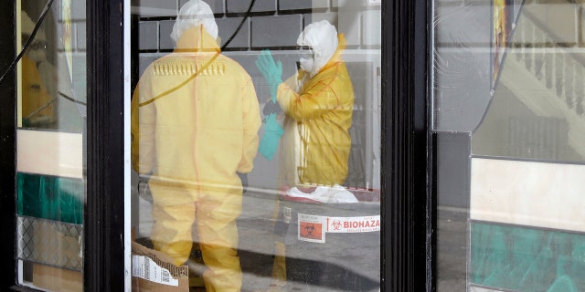 In this Thursday, April 2, 2020, file photo, workers in hazardous material suits clean inside the Abigail Hotel in San Francisco. The hotel is one of several private hotels San Francisco has contracted with to take vulnerable people who show symptoms or are awaiting test results for the coronavirus.