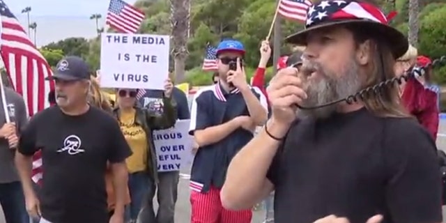 Hundreds gathered Sunday in San Clemente, Calif. gathered to protest California's stay-at-home order meant to slow the spread of coronavirus.