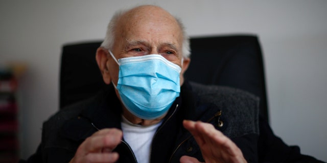 French doctor Christian Chenay, 98 year-old, wearing a protective face mask, sits in his consulting room at the doctor's office in Chevilly-Larue near Paris as the spread of the coronavirus disease (COVID-19) continues in France April 14, 2020. Picture taken April 14, 2020.