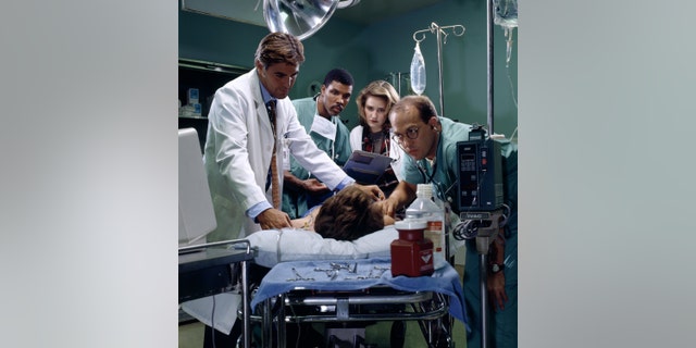 George Clooney as Doctor Doug Ross, Eriq La Salle as Doctor Peter Benton, Sherry Stringfield as Doctor Susan Lewis, and Anthony Edwards as Doctor Mark Greene in 'ER.'