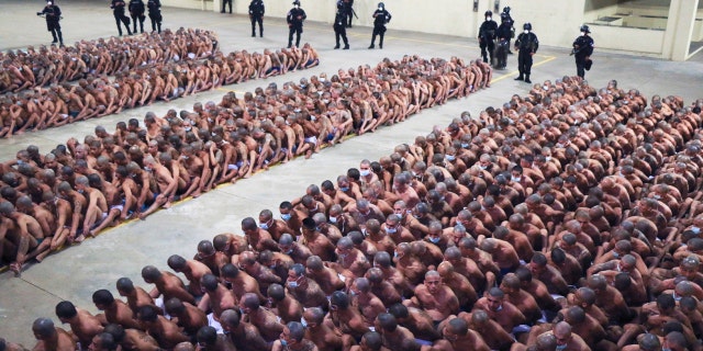 Police wearing masks as a precaution against the new coronavirus guard inmates, also wearing masks, during a security operation after President Nayib Bukele decreed maximum emergency in prisons housing gang members at the Izalco prison in San Salvador, Saturday, April 25, 2020.