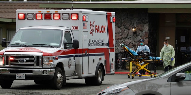 EMT's move a stretcher at the Gateway Care and Rehabilitation Center on Thursday, in Hayward, Calif. At least 13 patients at the facility have died of coronavirus, and 41 others have been infected.