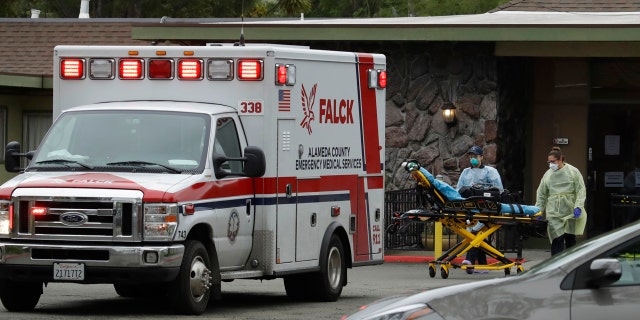 EMT's move a stretcher at the Gateway Care and Rehabilitation Center on Thursday, in Hayward, Calif. At least 13 patients at the facility have died of coronavirus, and 41 others have been infected.