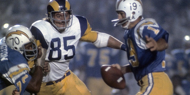 Quarterback Johnny Unitas of the San Diego Chargers scrambles away from defensive end Jack Youngblood of the Los Angeles Rams during a football game at Jack Murphy Stadium in San Diego, California during the 1973 NFL season. (Photo by Focus on Sport/Getty Images)