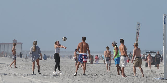 A group of people play volleyball on the beach in its first open hour on April 17, 2020 in Jacksonville Beach, Fl. 