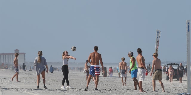 A group of people play volleyball on the beach in its first open hour on April 17, 2020 in Jacksonville Beach, Fl.