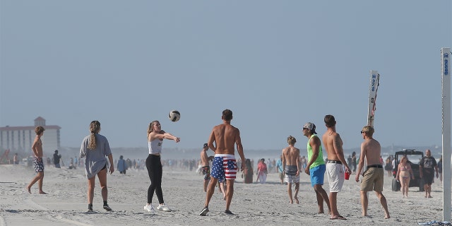 A group of people play volleyball on the beach in its first open hour on April 17, 2020 in Jacksonville Beach, Fl. 