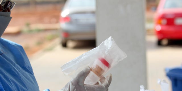 Staff in Ghana unbox a COVID-19 test sample that was transported via drone from a rural village.