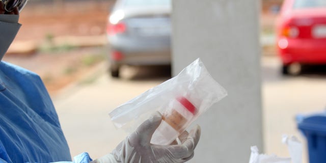 Staff in Ghana unbox a COVID-19 test sample that was transported via drone from a rural village.