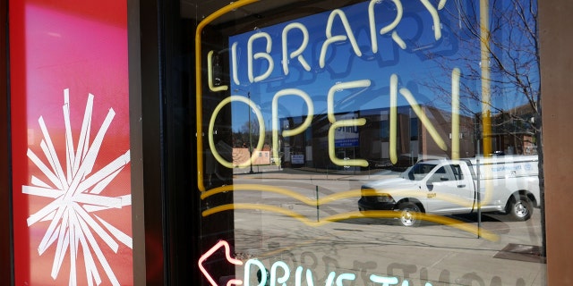 A library is shown with an "open" sign and directions for "drive-thru" service.