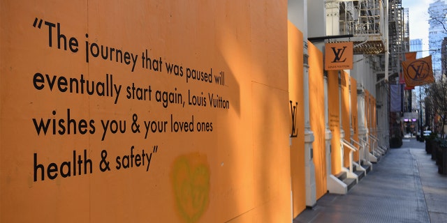 A message is displayed on a boarded up Louis Vuitton storefront in the SoHo neighborhood of New York City on April 1, 2020. - The US on Wednesday has surpassed 200,000 confirmed cases of the novel coronavirus, according to a tally kept by Johns Hopkins University.