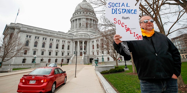 Protesters against the coronavirus shutdown rally in front of State Capitol in Madison, Wisconsin, on April 24, 2020. - The coronavirus pandemic soared past 50,000 in the US. (Photo by KAMIL KRZACZYNSKI / AFP) (Photo by KAMIL KRZACZYNSKI/AFP via Getty Images)